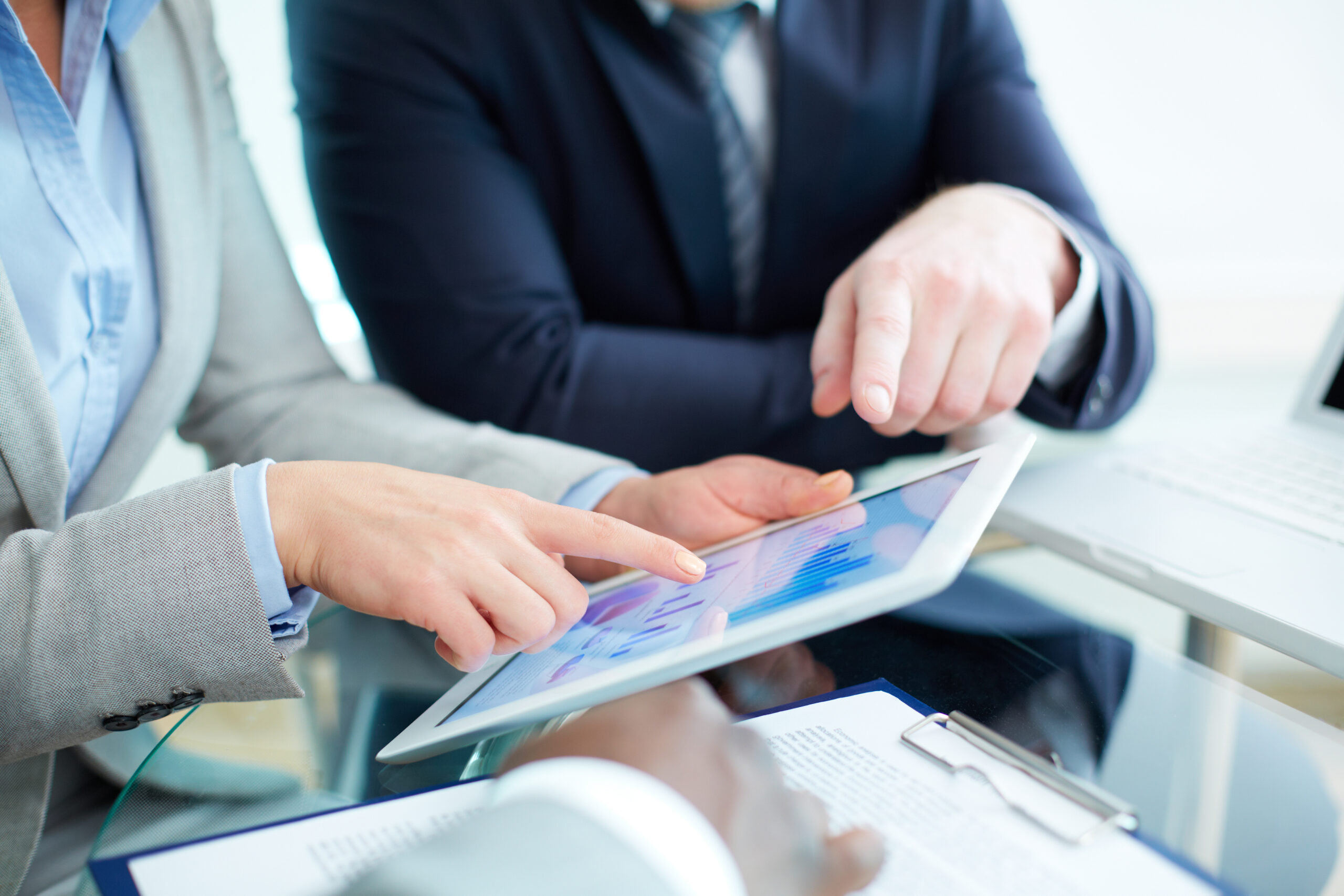 Image of human hands during discussion of business document in touchscreen at meeting